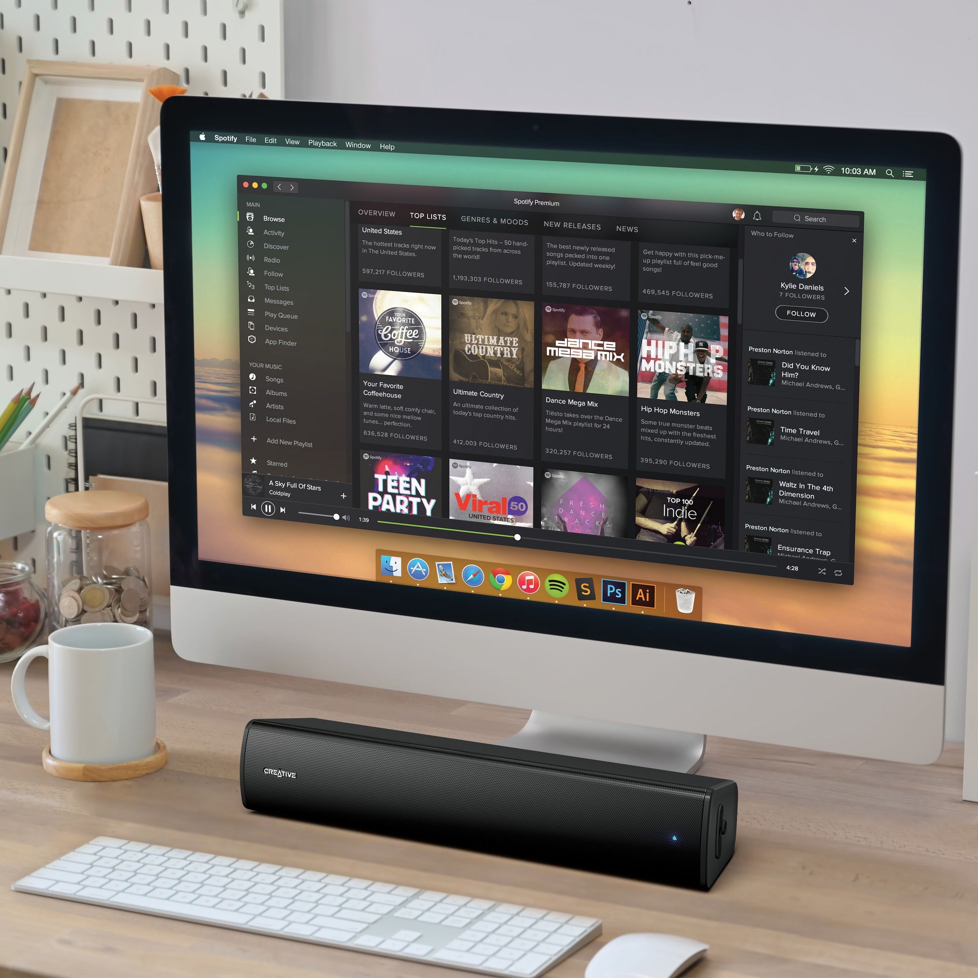 Creative Scene Air V2 Bluetooth soundbar og sort Creative højttaler på skrivebord ved pc med tastatur, mus, kop, notesblok.