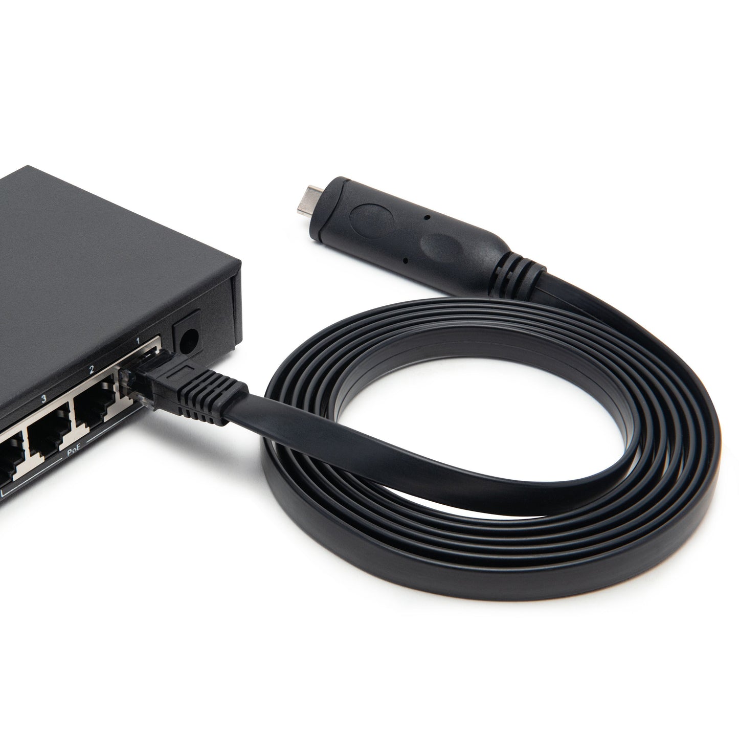 Luxorparts konsolkabel USB-C, flad sort netværkskabel med FTDI-chip, USB-C og konsolportstik, ses rullet ved switch.