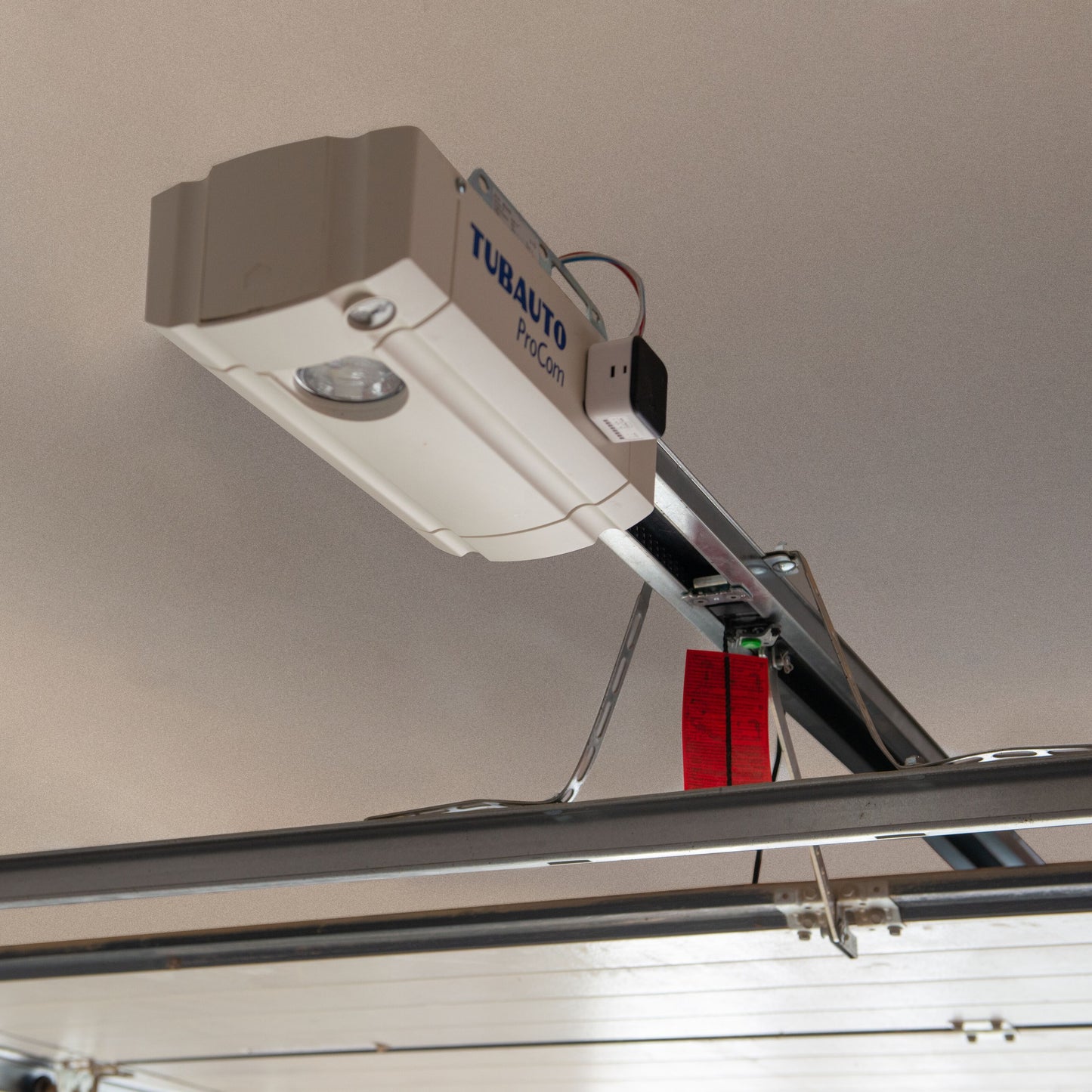 Yale Smart garageportåbner, loftmonteret med metalskinne og rød nødudløser, app-styret via Yale Home.