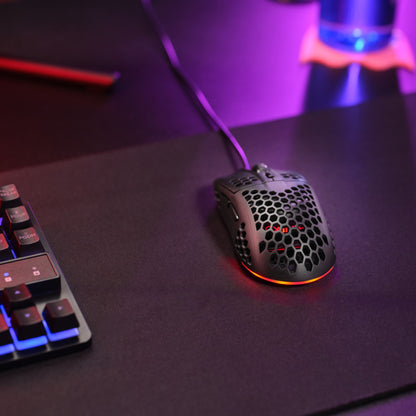 Trust Helox GXT928 gamingmus, sort, letvægts, justerbar DPI, rød LED, på mørk musemåtte ved mekanisk tastatur.