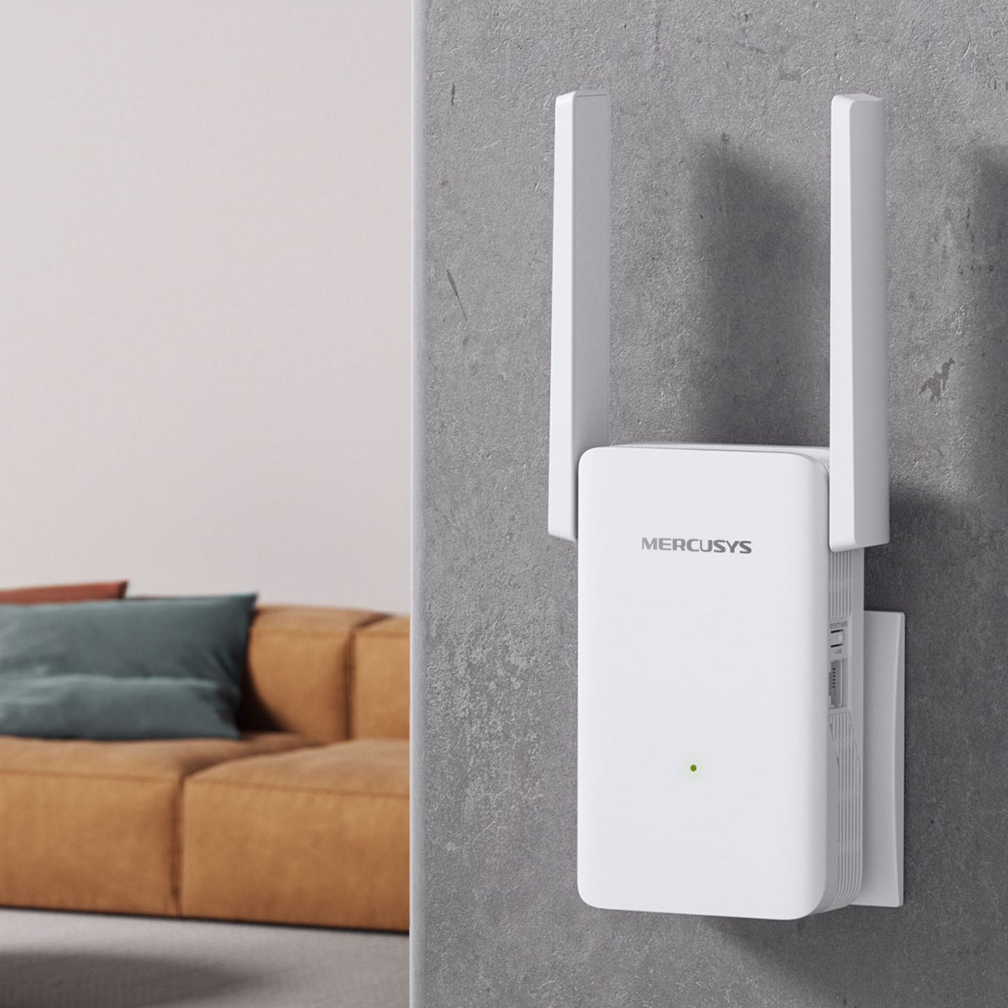 Mercusys ME80X Wi-Fi 6 Repeater AX3000 med to antenner i stikkontakt, gul sofa med grønne og blå puder bagved.
