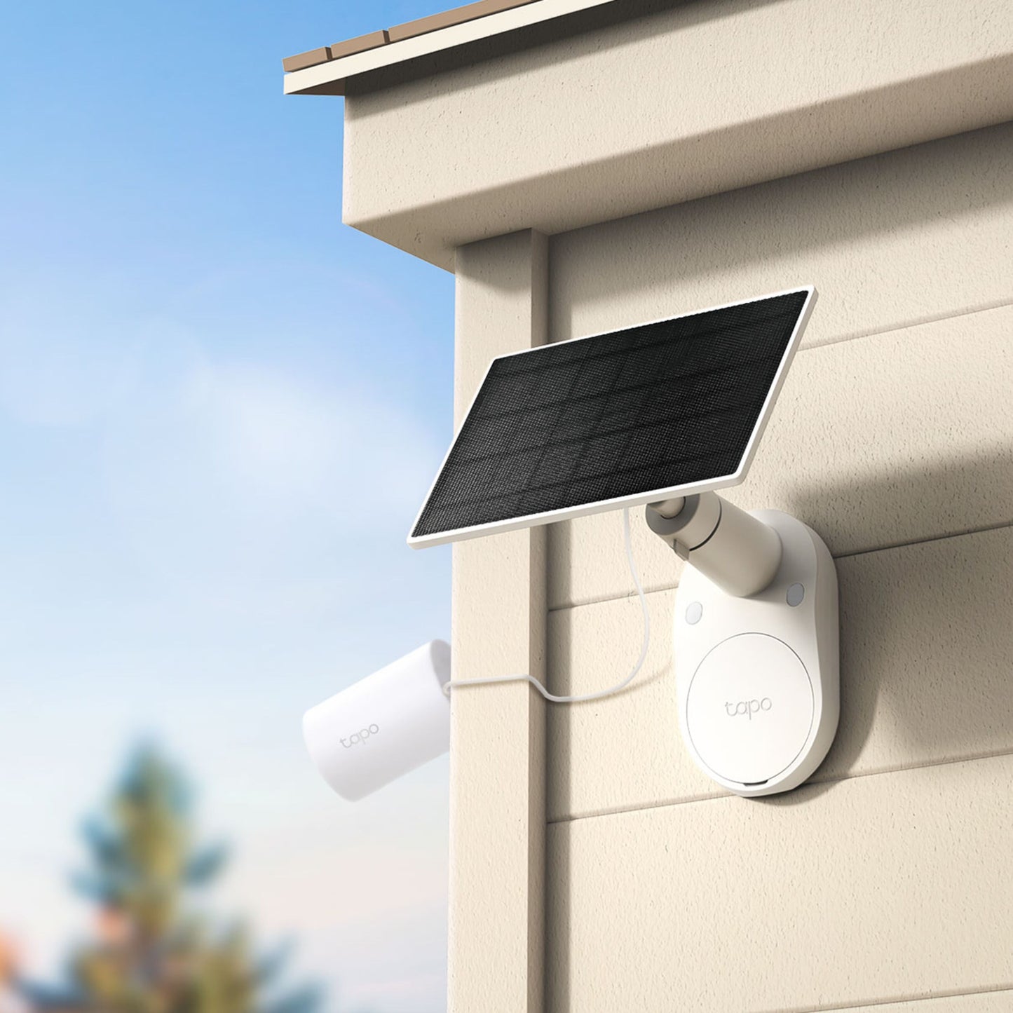 TP-Link Tapo A201 solcellepanel monteret udendørs på lys væg, tilsluttes overvågningskamera med synligt USB-C kabel.