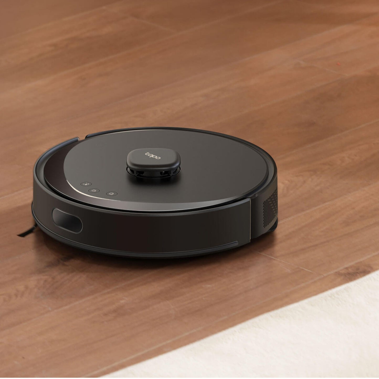 TP-Link Tapo RV30 Max robotstøvsuger på trægulv ved siden af hvidt tæppe.