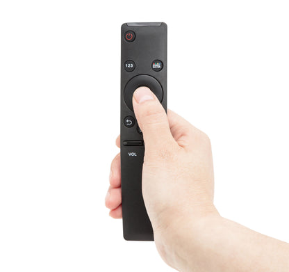 Sort Samsung Smart TV fjernbetjening, central knap trykkes ned med tommelfinger.
