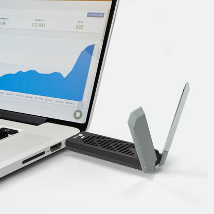 TP-Link Bueskytte TBE400UH WiFi 7 USB netværkskort sort/grå med to antenner tilsluttet laptop USB-port.