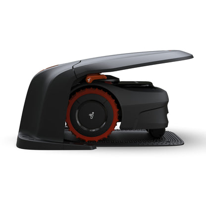 Segway Navimow i105 robotplæneklipper sort/orange på base delvist under Garage S1A02E buet overdækning.