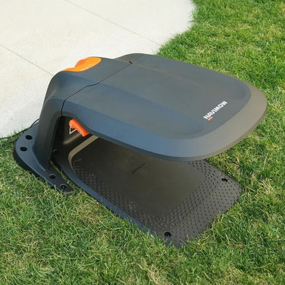 Segway Garage S1A02E til Navimow i105/i208E AWD med sort og orange beskyttelse på græs ved beton-kant.
