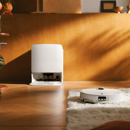 Roborock Qrevo Edge 2 Pro robotstøvsuger med moppe på trægulv ved hvidt tæppe og ladestation op ad trævæg.