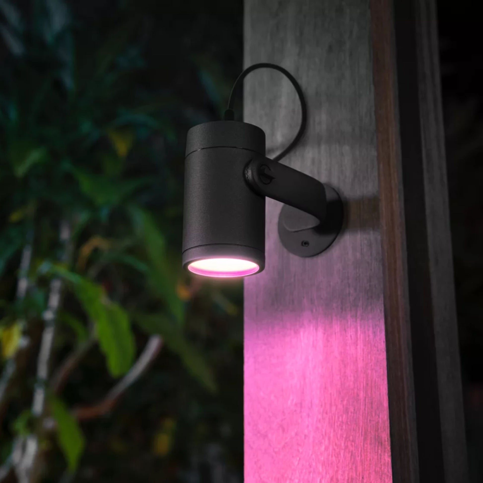 Philips Hue Lily spotlys udendørs 3-pak, blød rosa belysning på træstolpe, kompatibel med app-styret belysning.