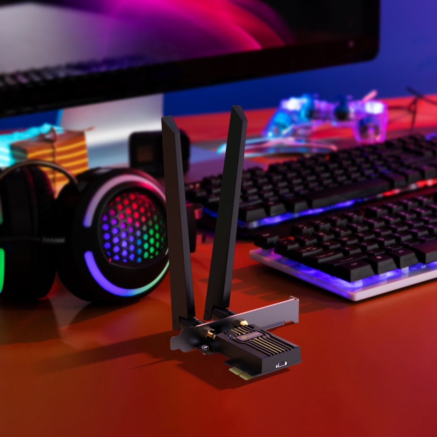 TP-Link Archer TBE400E Wi-Fi 7 PCIe netværkskort med to antenner på skrivebord foran tastatur og skærm med LED-lys.