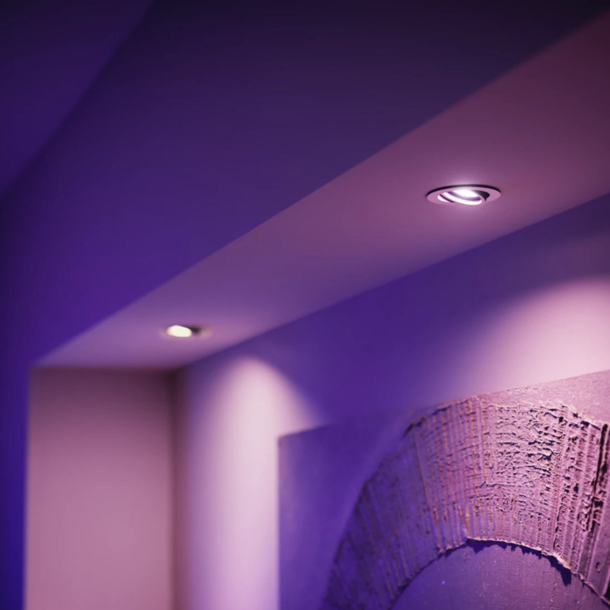 Philips Hue White and Color ambiance smart LED-pærer GU10 400 lm i lilla/pink lyser rummet, vægkunst til højre.