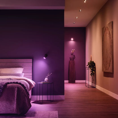 Hue Hvid og farve ambiance smart LED-pære GU10 400 lm 2-pak lyser soveværelse op med lilla og pink toner, synlige detaljer.