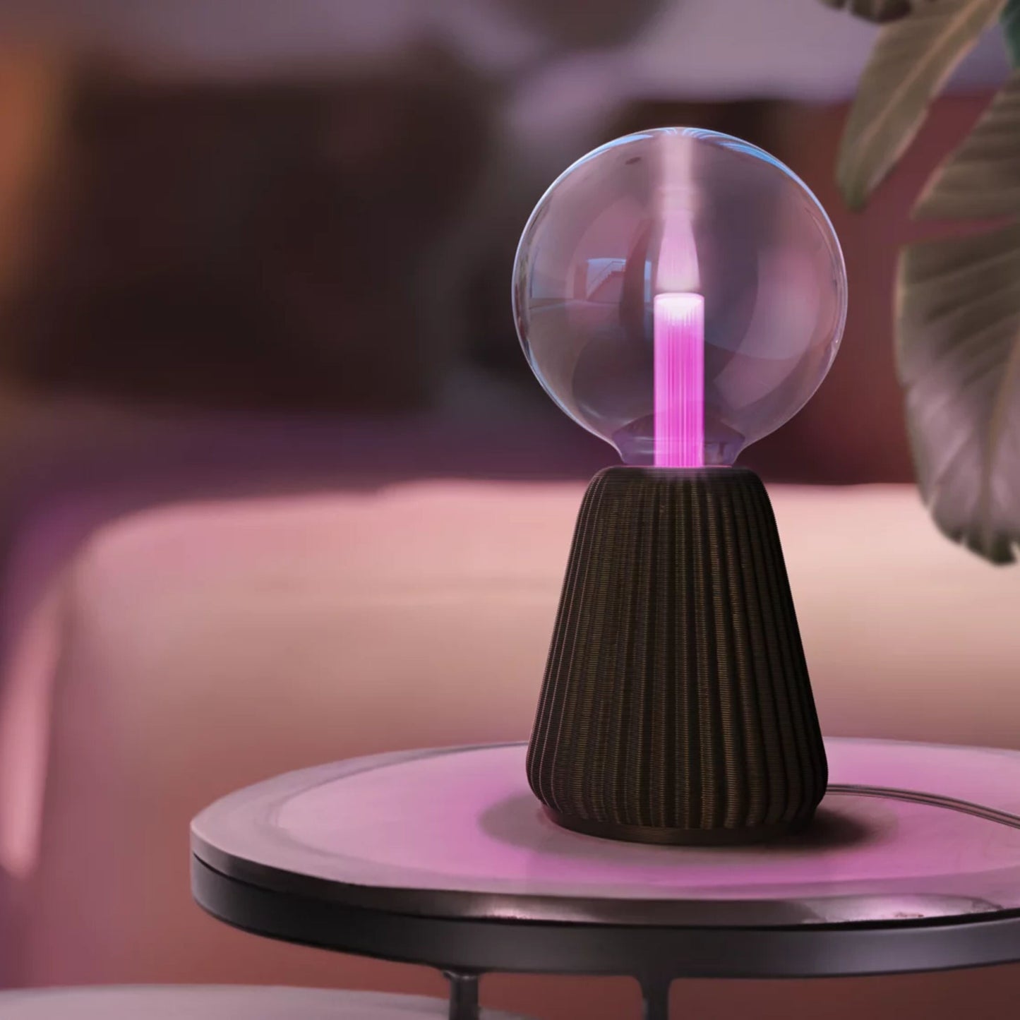 Plasmalampe med klar glaskuppel og pink lys på mørk rillet sokkel ved siden af Philips Hue Lightguide G125 E27 LED pære.