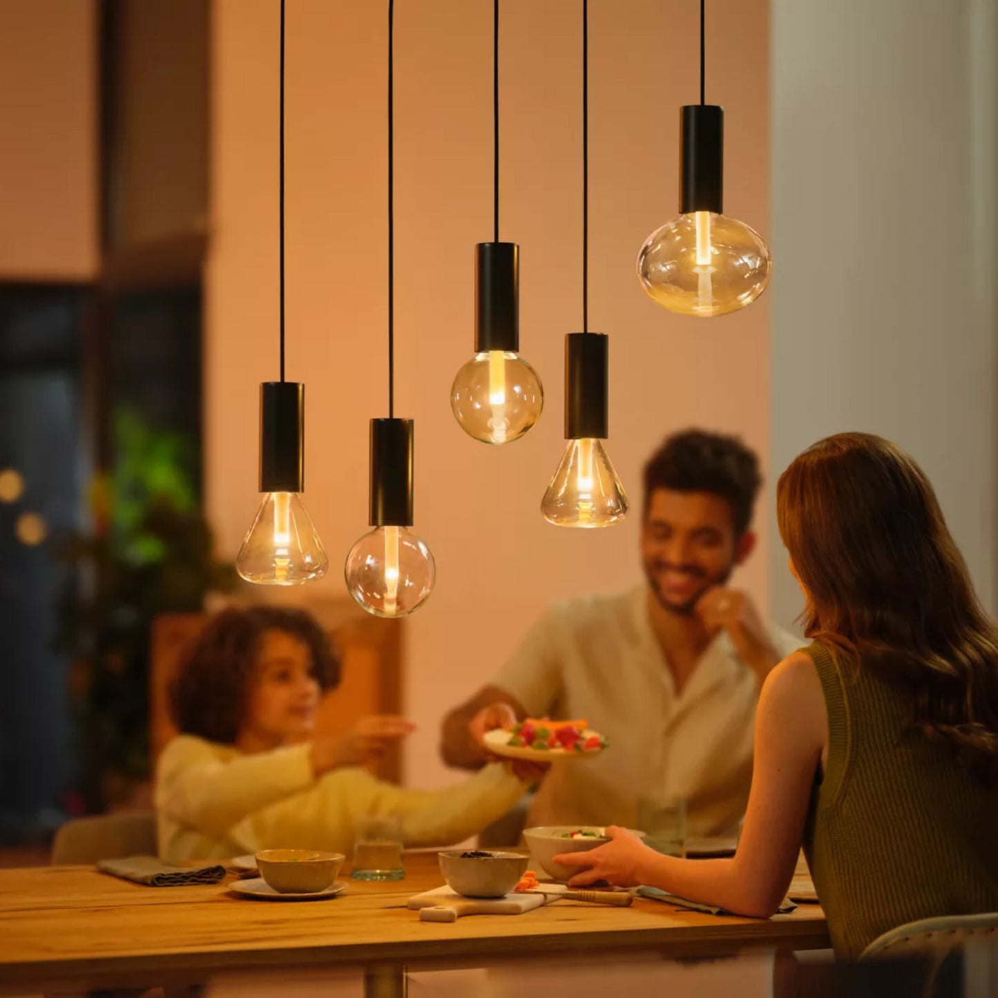 Philips Hue RGB G95 Smart LED-pære E27 500 lm monteret i moderne pendellamper over spisebord.