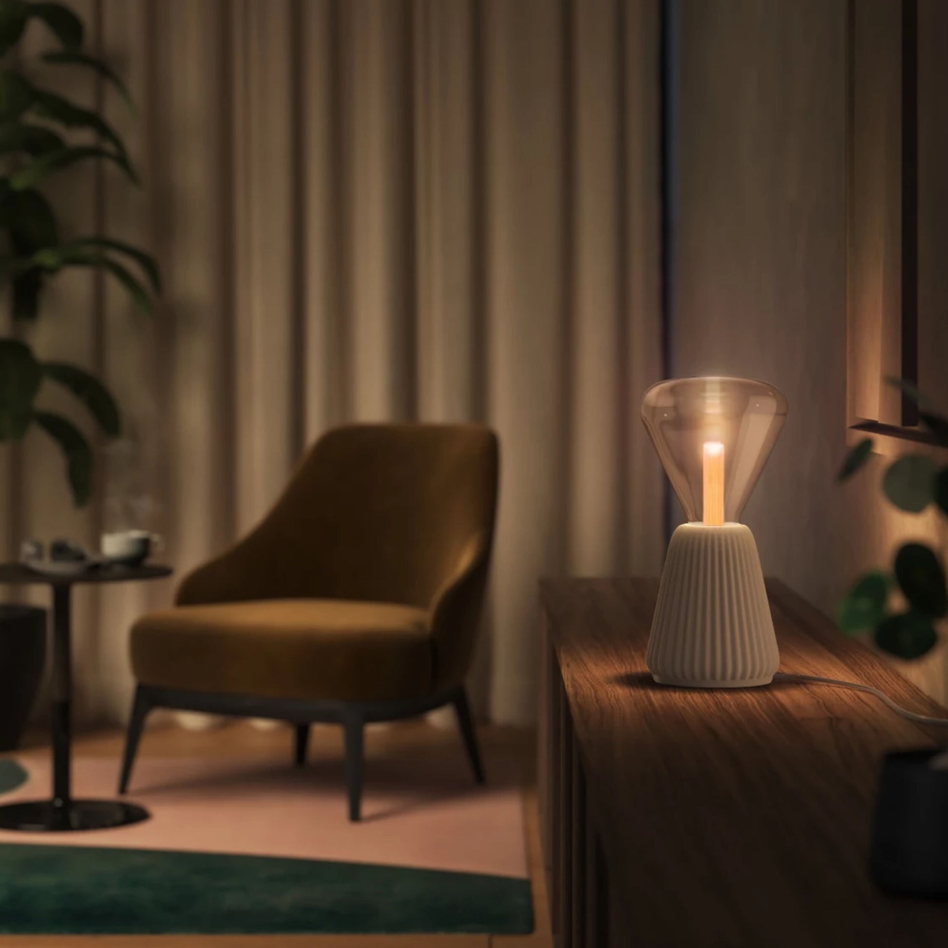 Philips Hue Lightguide Triangle E27 smart LED-pære 500 lm på træskab foran beige gardiner og grønne planter.