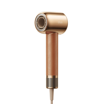Dreame Hair Miracle hårtørrer, guld og brun, cylindrisk design, lædertekstureret håndtag, metalliske detaljer.