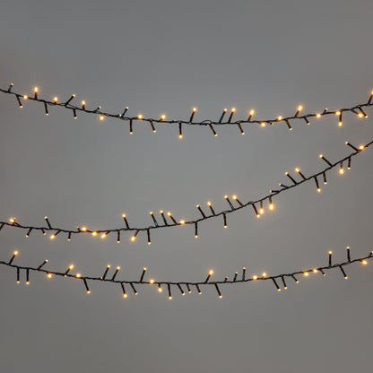 Lyskæde 2000 LED 40 m sort hænger vandret, lyser med varm hvid farve, synlige sorte ledninger.