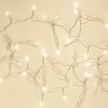 Lyskæde 48 LED 3,5m klar med snoede ledninger og klare pærer, udstrakt på beige flade.