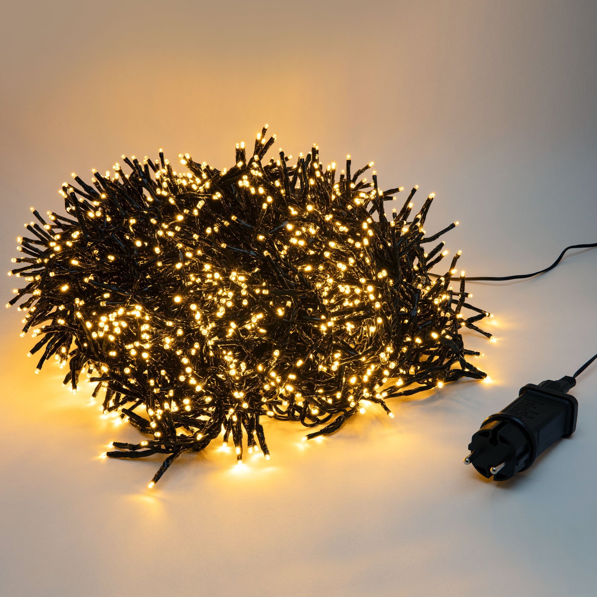 Lyskæde Kluster 2250 LED 15m sort, varme hvide cluster-LEDs på sort ledning, tilsluttet sort adapter.