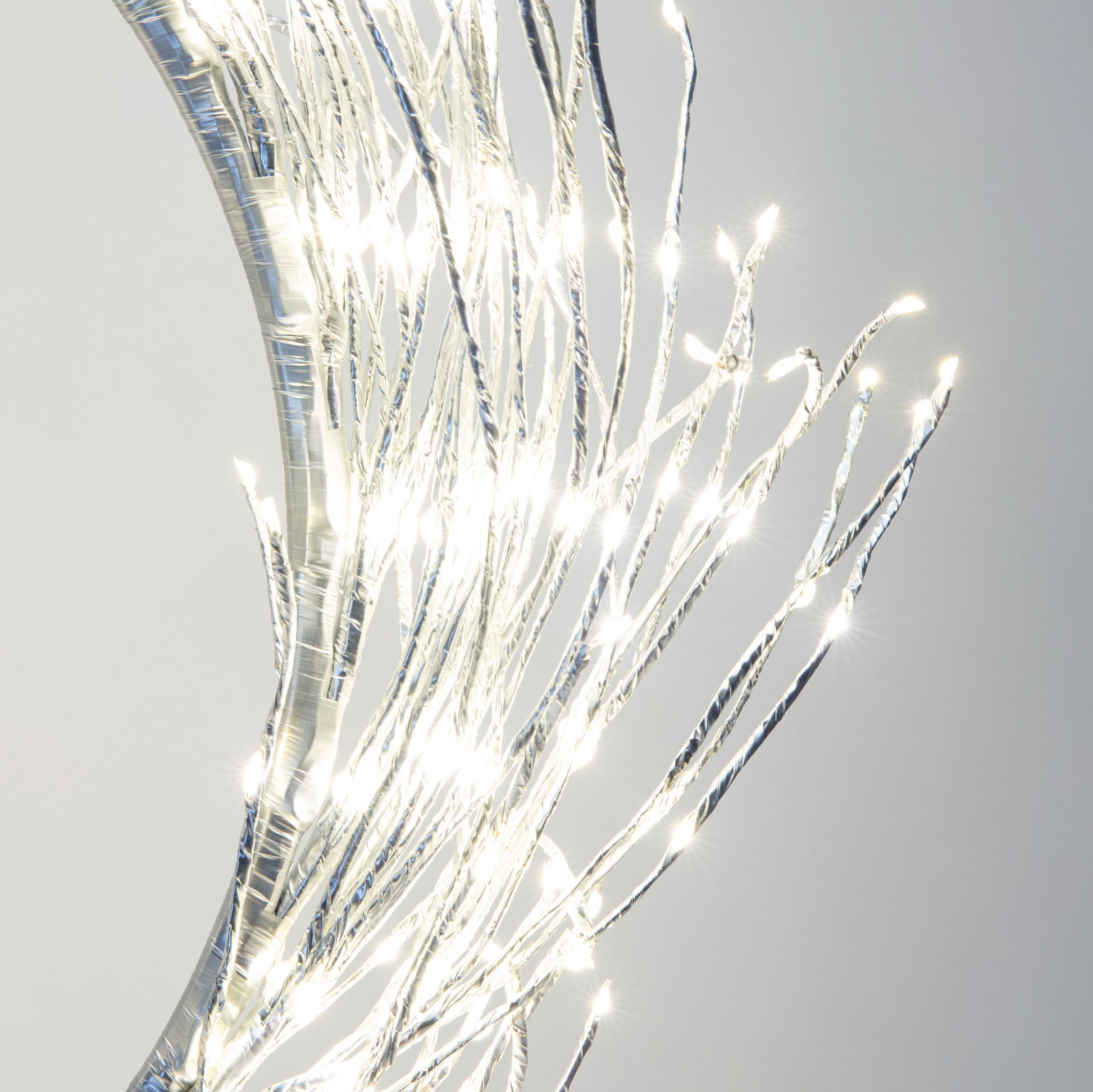Lyskæde Ring 936 LED Ø50 cm sølv, nære grene omviklet med LED-lys, fremhæver blank overflade.