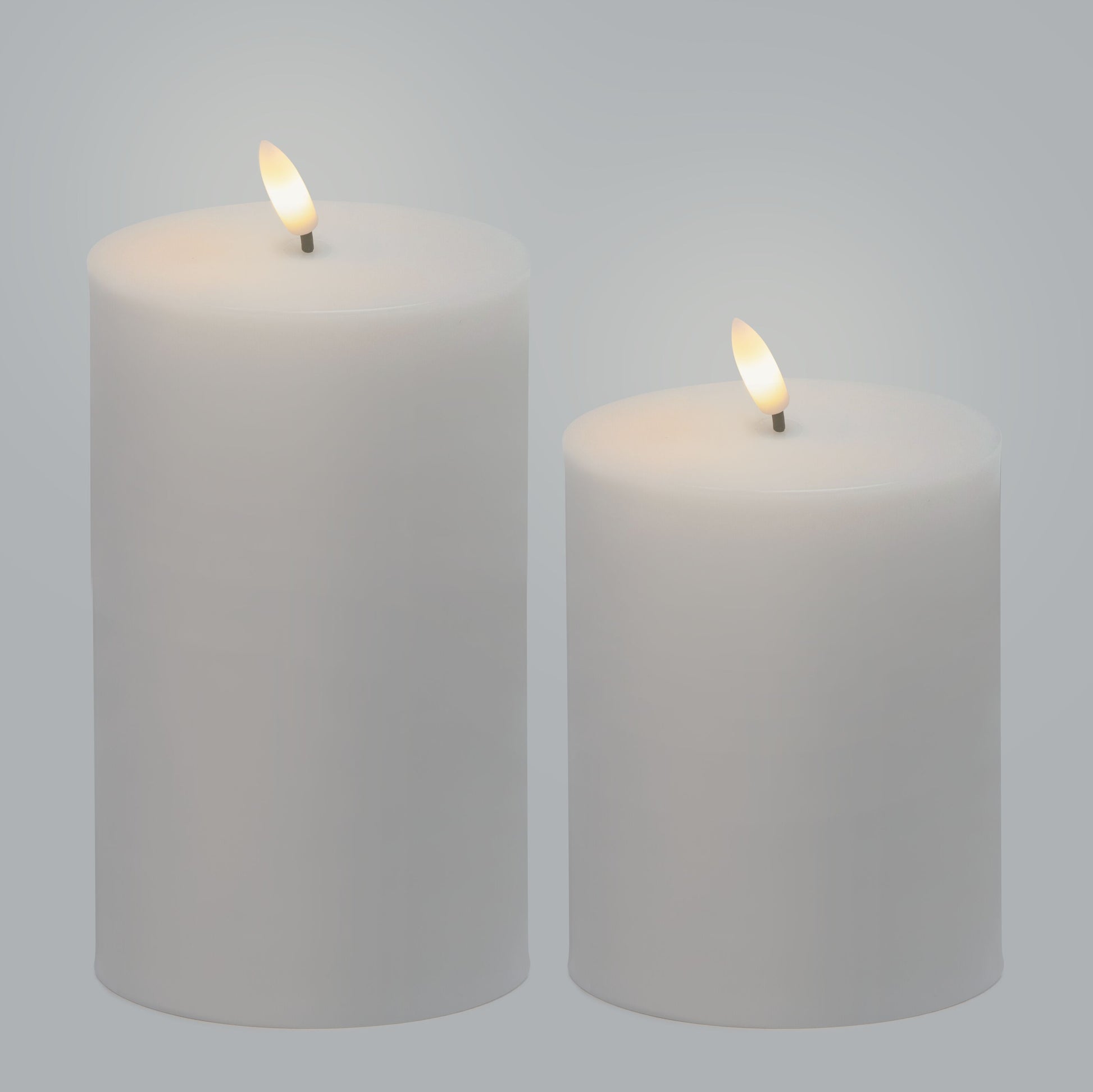 LED bloklys udendørs 2-pak, hvide, tændte, til forskellige højder, placeret ved siden af hinanden.