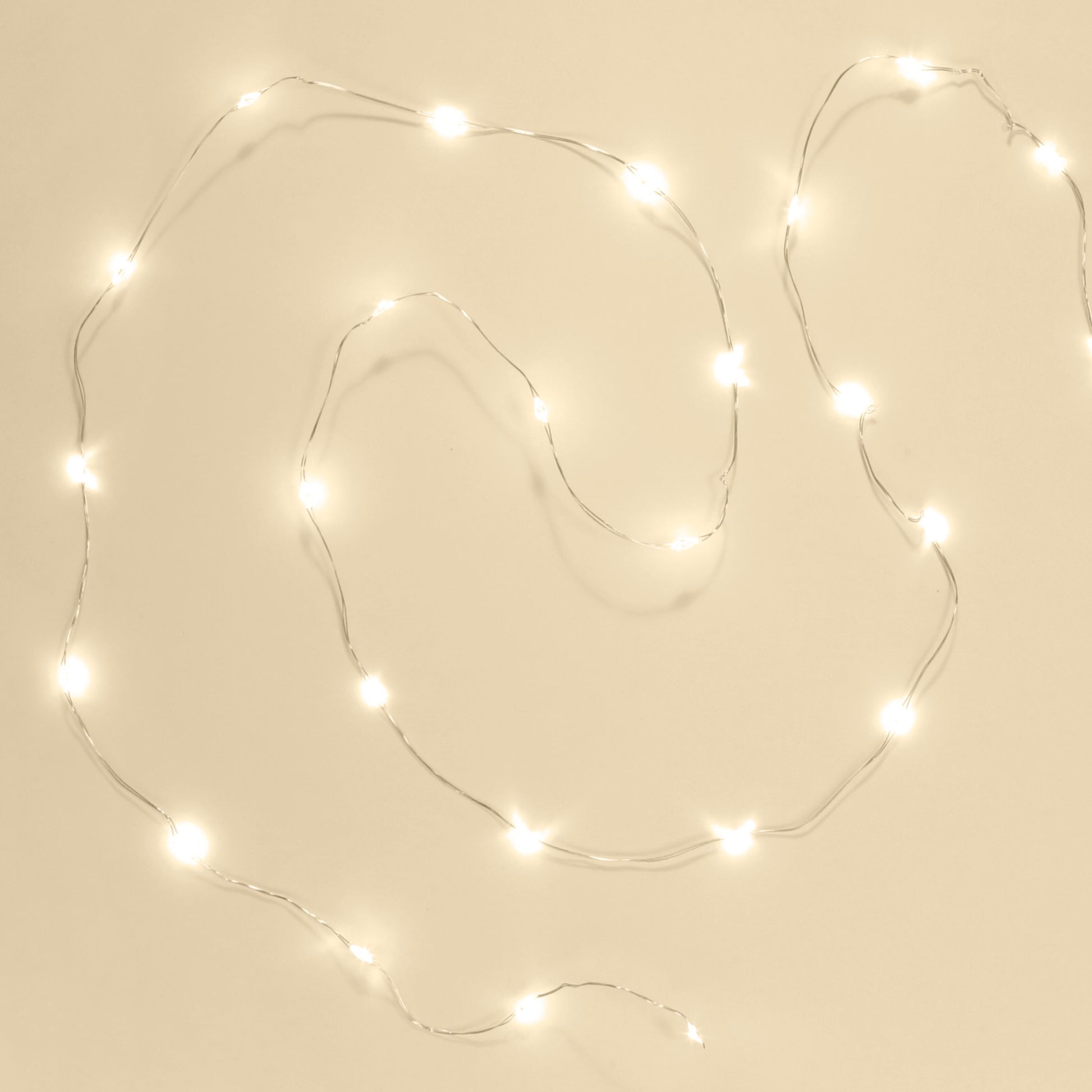 Lyskæde Micro 40 LED 1,95m sølv med timerfunktion ses i løs bølgeform, lyser med varm hvid farve.