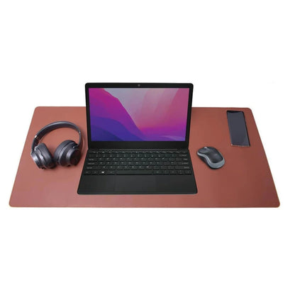 Desire2 skrivebordsmåtte vegansk læder 900x400 mm brun med laptop, trådløs mus, over-ear hovedtelefoner og smartphone ovenpå.
