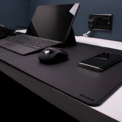 Desire2 skrivebordsmåtte vegansk læder grå 90x45 cm på kontorbord med tablet, tastatur, mus, smartphone og stik/ladekabler.