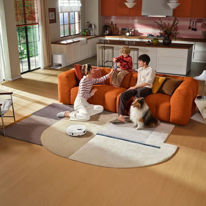 Roborock Qrevo 2 Pro robotstøvsuger med moppefunktion i hvid på et mønstret tæppe i stuen, hvor familien holder til.