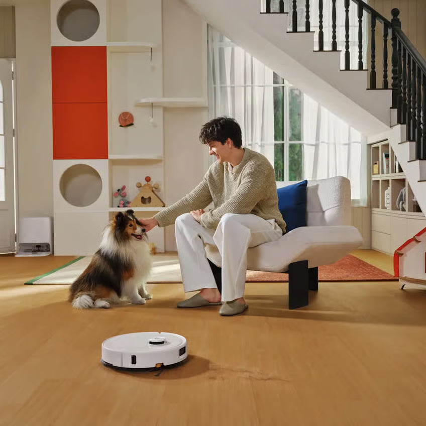 Roborock Qrevo 2 Pro robotstøvsuger med moppefunktion, hvid, på trægulv i en lys stue med store vinduer og trapper.