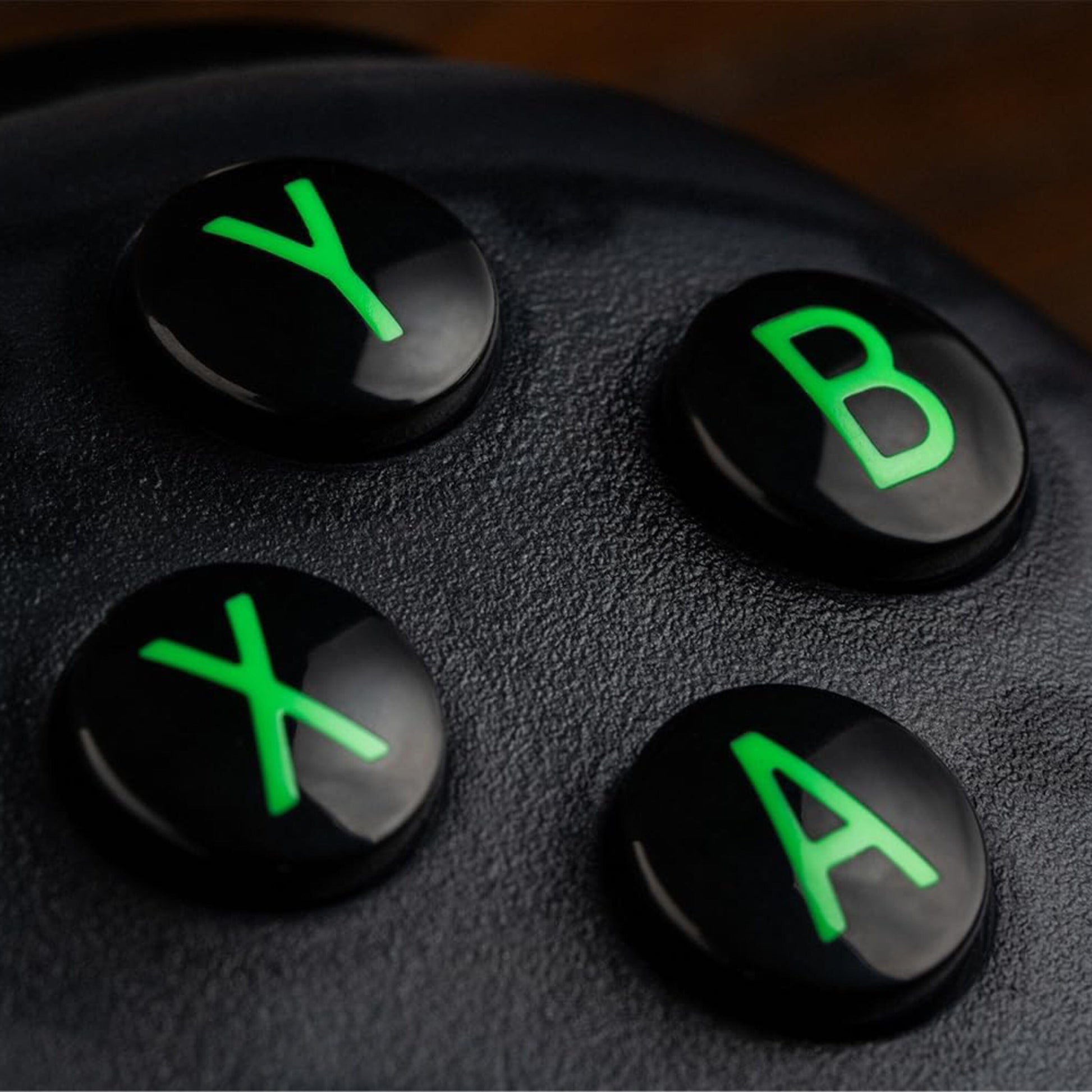 8Bitdo Ultimate 2C trådløs controller Transparent Sort, nærbillede af grønne Y, B, X, A-knapper med Hall Effect-teknologi.