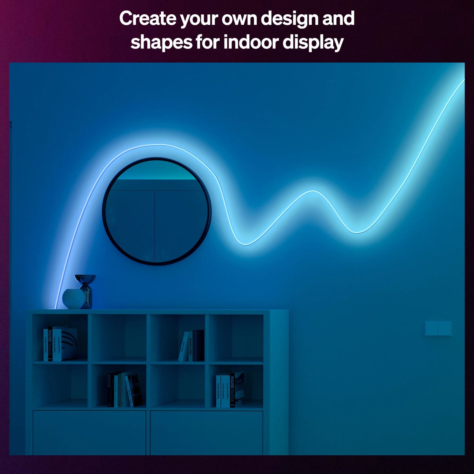 Philips Hue Essential Flex LED-liste 5m dæmpbar RGBIC bøjet over mørkeblå væg med hvid reol og rundt spejl.