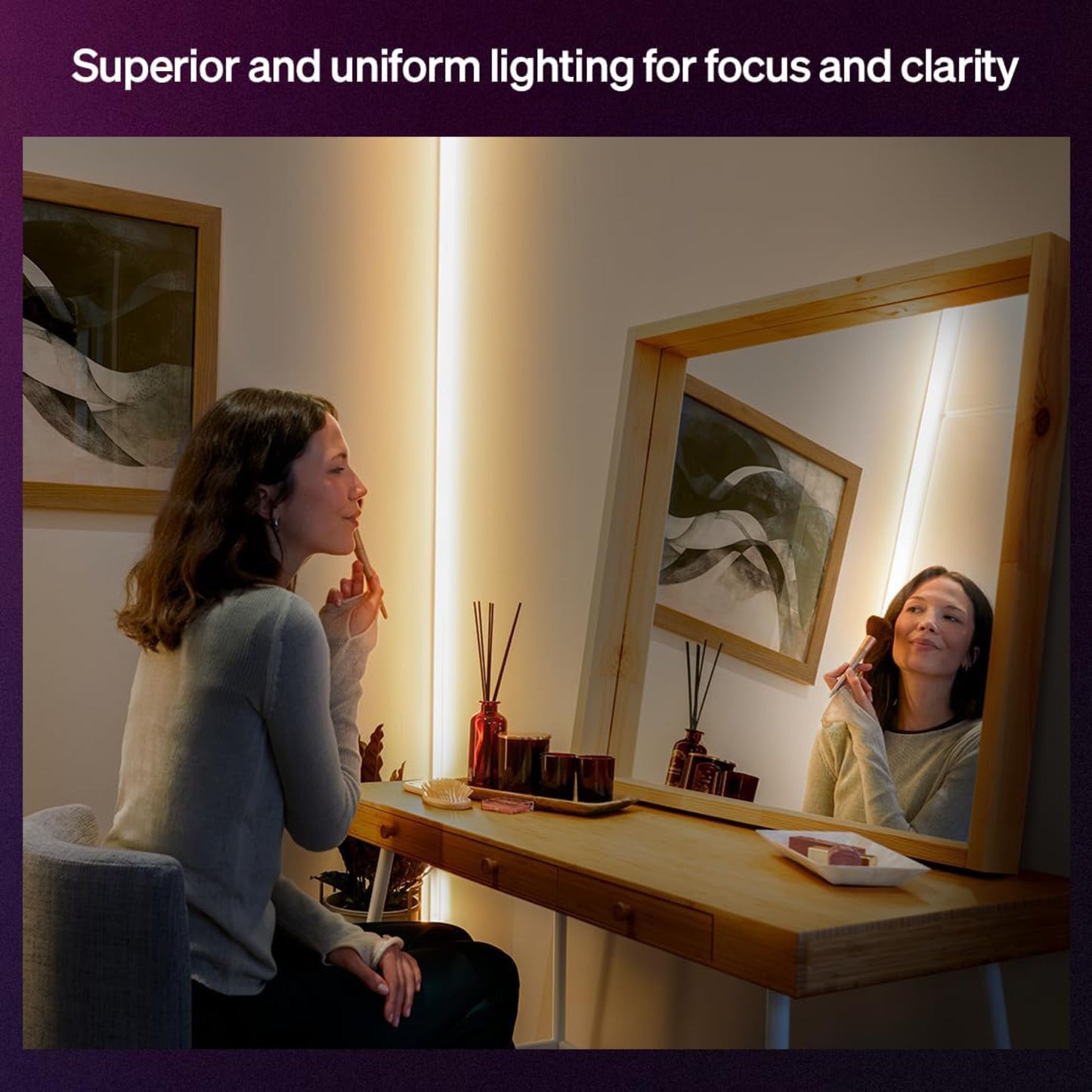 Philips Hue OmniGlow smart lysliste med fuld farveskala monteret rundt om spejl på træbord ved makeup-anvendelse.