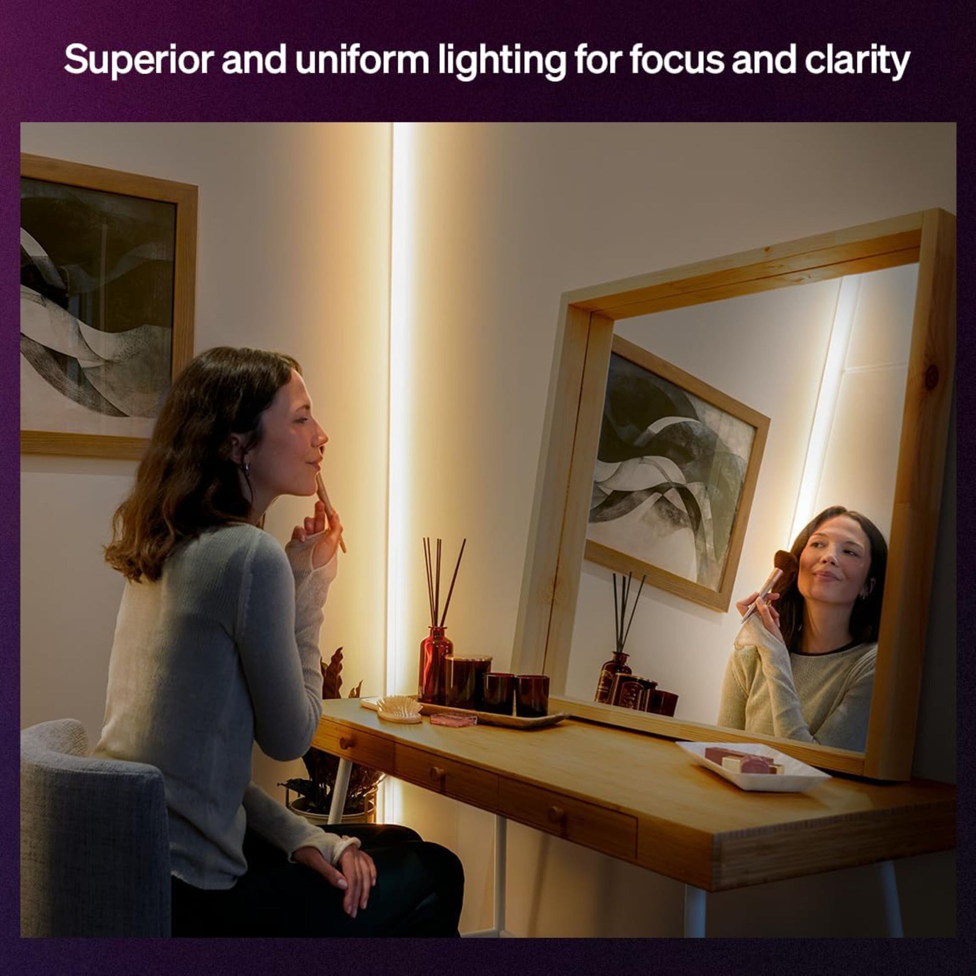 Philips Hue OmniGlow smart lysliste med fuld farveskala monteret rundt om spejl på træbord ved makeup-anvendelse.