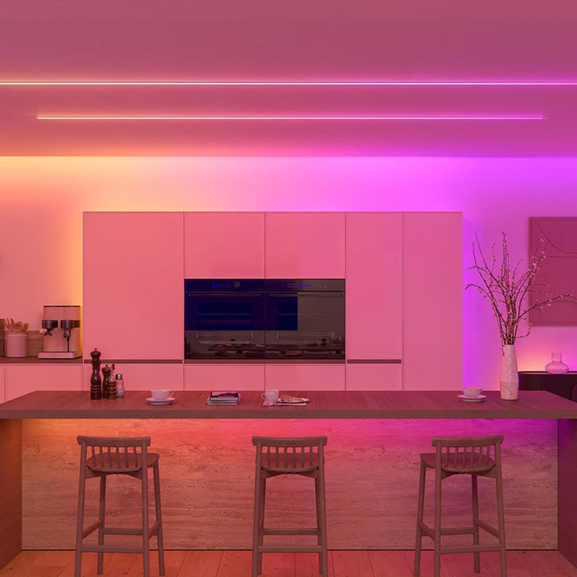 Philips Hue OmniGlow smart lysliste med fuld farveskala dæmpbar, viser pink, lilla og orange belysning i køkkenmiljø.