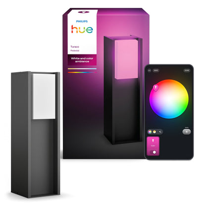 Philips Hue Turaco udendørslampe antracit ved æske, smartphone med farvet lysstyringsinterface vises.