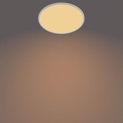 Philips Hue Loftlampe CL550 22W SceneSwitch hvid, varm gylden belysning, centreret mod mørk til taupe baggrund.