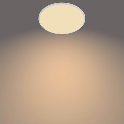 PhilipsHue Loftlampe CL550 22W SceneSwitch hvid, varmt hvidt lys, ses på grå loft med cirkulær lyseffekt.