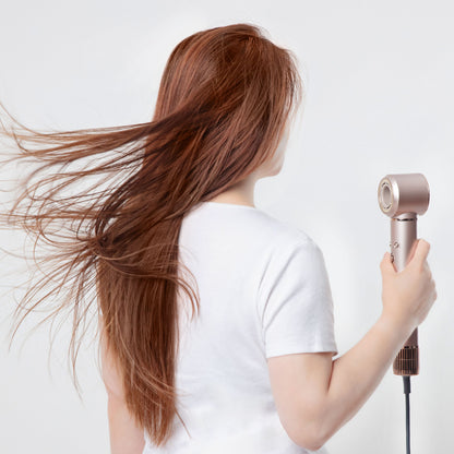 Person med langt, rødt hår holder High-speed Multistyler 7-i-1 hårtørrer med BLDC-motor.
