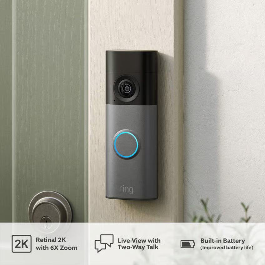 Ring batteridrevet videodørklokke + dørklokke, speckled grey ved lys dør; ikonerne viser 2K-opløsning, live-visning, tovejskommunikation, batteri, helkropsbillede.