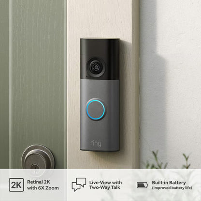 Ring batteridrevet videodørklokke + dørklokke, speckled grey ved lys dør; ikonerne viser 2K-opløsning, live-visning, tovejskommunikation, batteri, helkropsbillede.