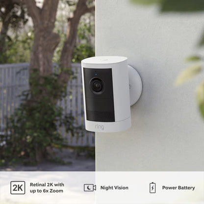 RING Outdoor Cam Plus Battery, Retinal 2K, hvid, monteret på ydervæggen med ikoner for 2K-opløsning, nattesyn og batteri.
