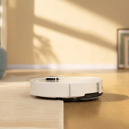Roborock Q10 VF+ robotstøvsuger med ladestation på lyst trægulv i rum med beige vægge og indrammet billede.