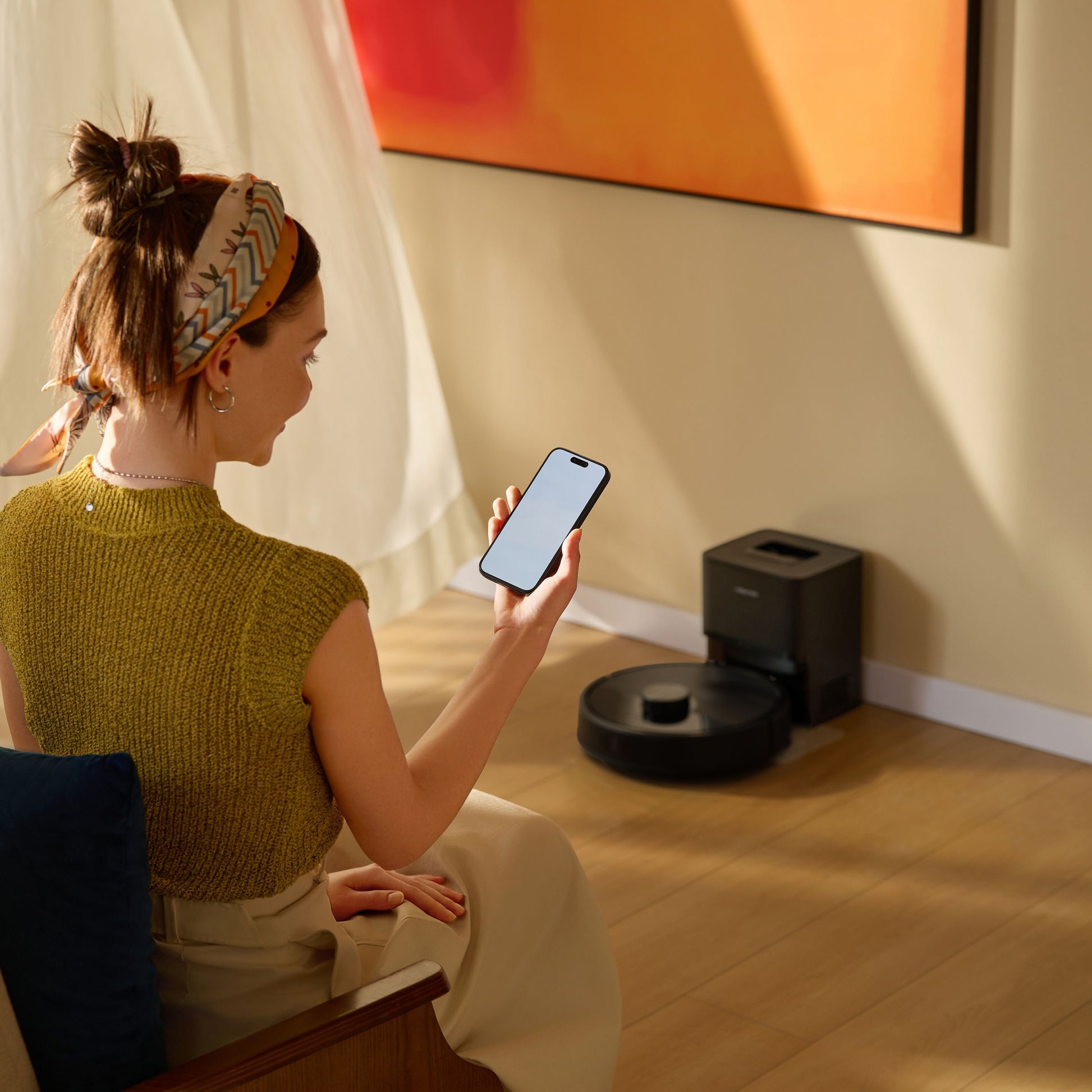 Roborock Q7 TF+ robotstøvsuger med ladestation i sort, styres via smartphone, synlig i stue med trægulv.