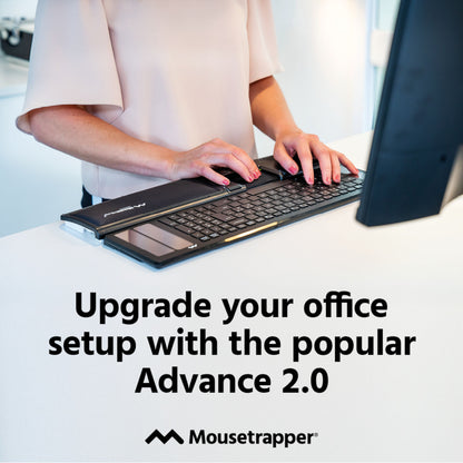 Mousetrapper Advance 2.0 ergonomisk mus med central styrplade ses ved tastatur på skrivebord.