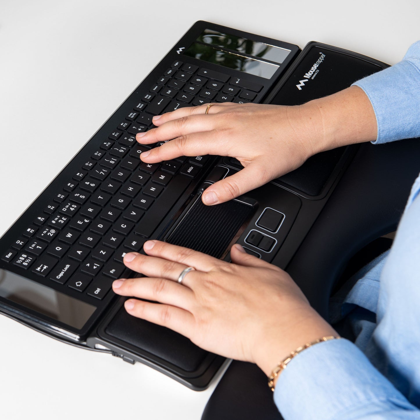Mousetrapper Advance 2.0 ergonomisk mus med central styreplade og integreret trackpad bruges på skødet.