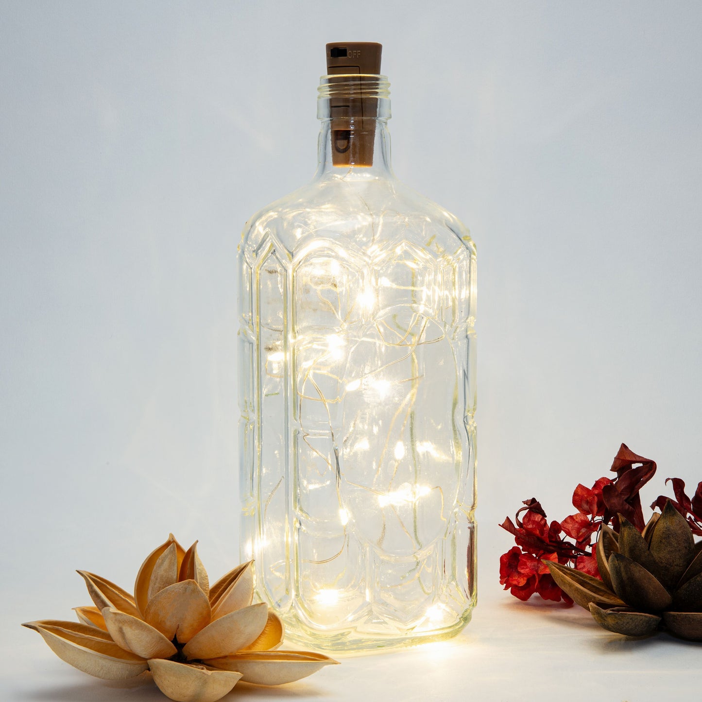 Rubicson Vinprop med LED-belysning i klar glasflaske med tørrede blomster i beige, rød og grøn.