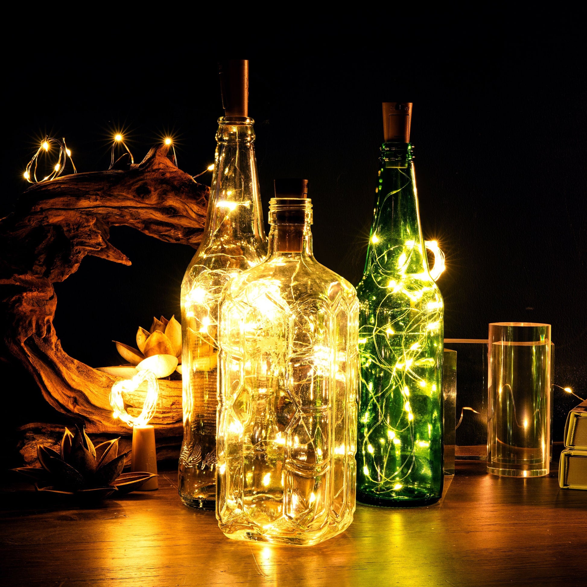 Rubicson glasflasker med Vinprop og LED-belysning på træbord, flere LED-lys synlige i mørk baggrund.