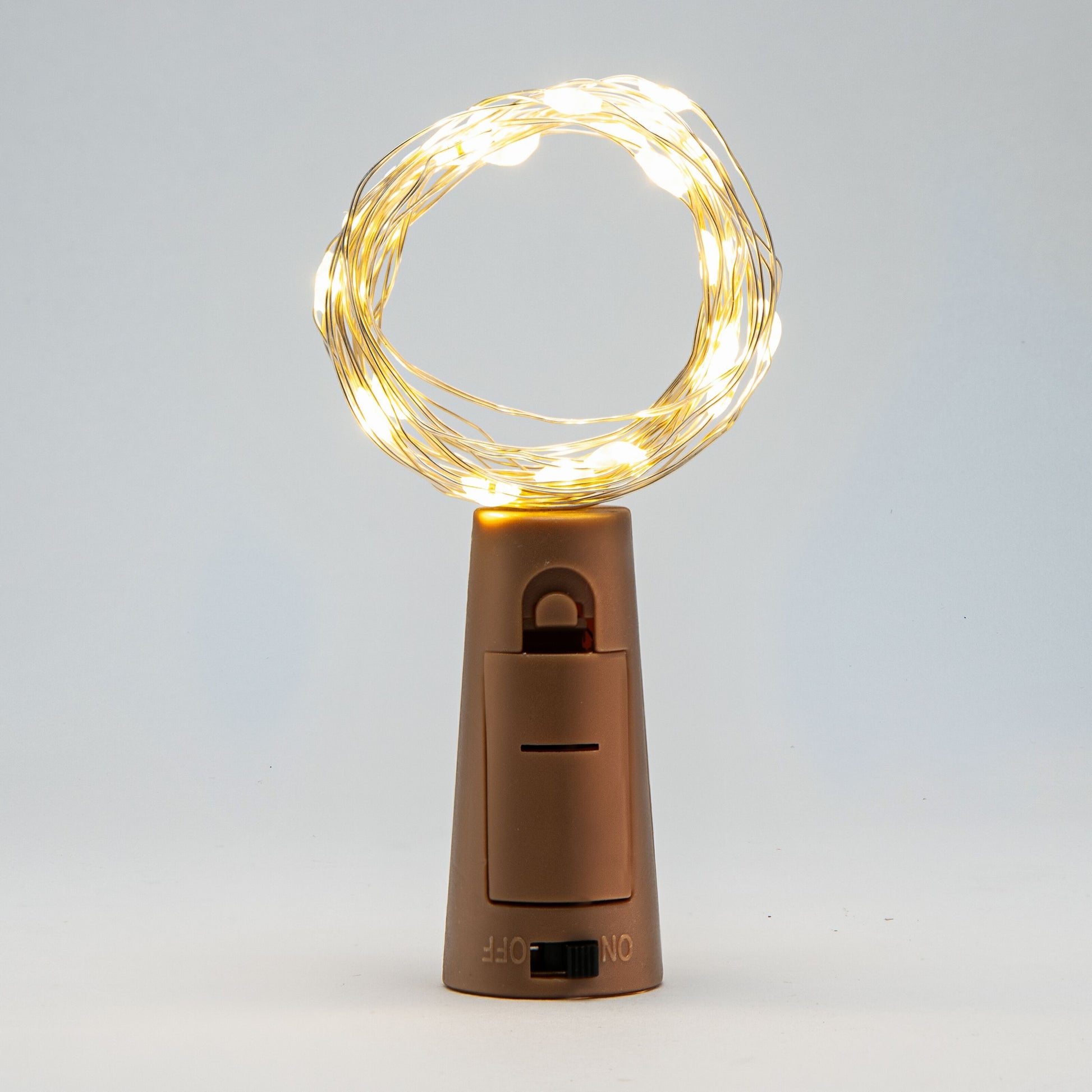 Vinprop med LED-belysning, kompakt brun batteridrevet lysbase med kontakt og synlig lystråd.