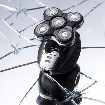 Remington Ultimate Series RX5 XR1500 barbermaskine, fem cirkulære blade, stående på sprækket reflekterende overflade.